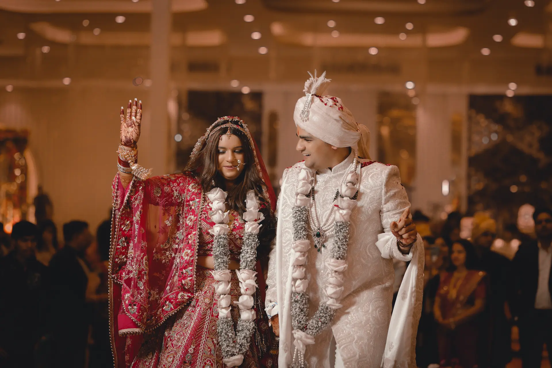 Walking couple Himanshu & Anuja waving during their wedding ceremony by The Wedding Galaxy